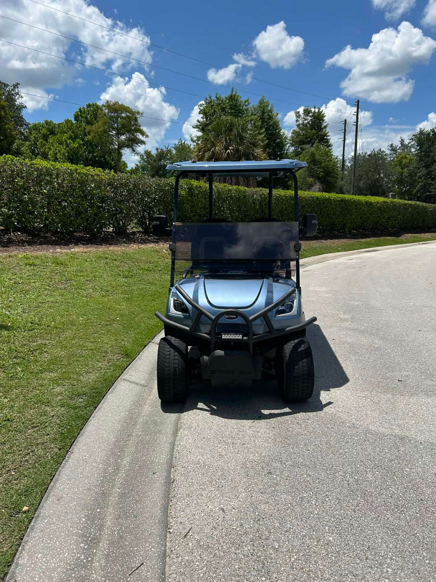 Light blue Star EV luxury golf cart on a resort walking path