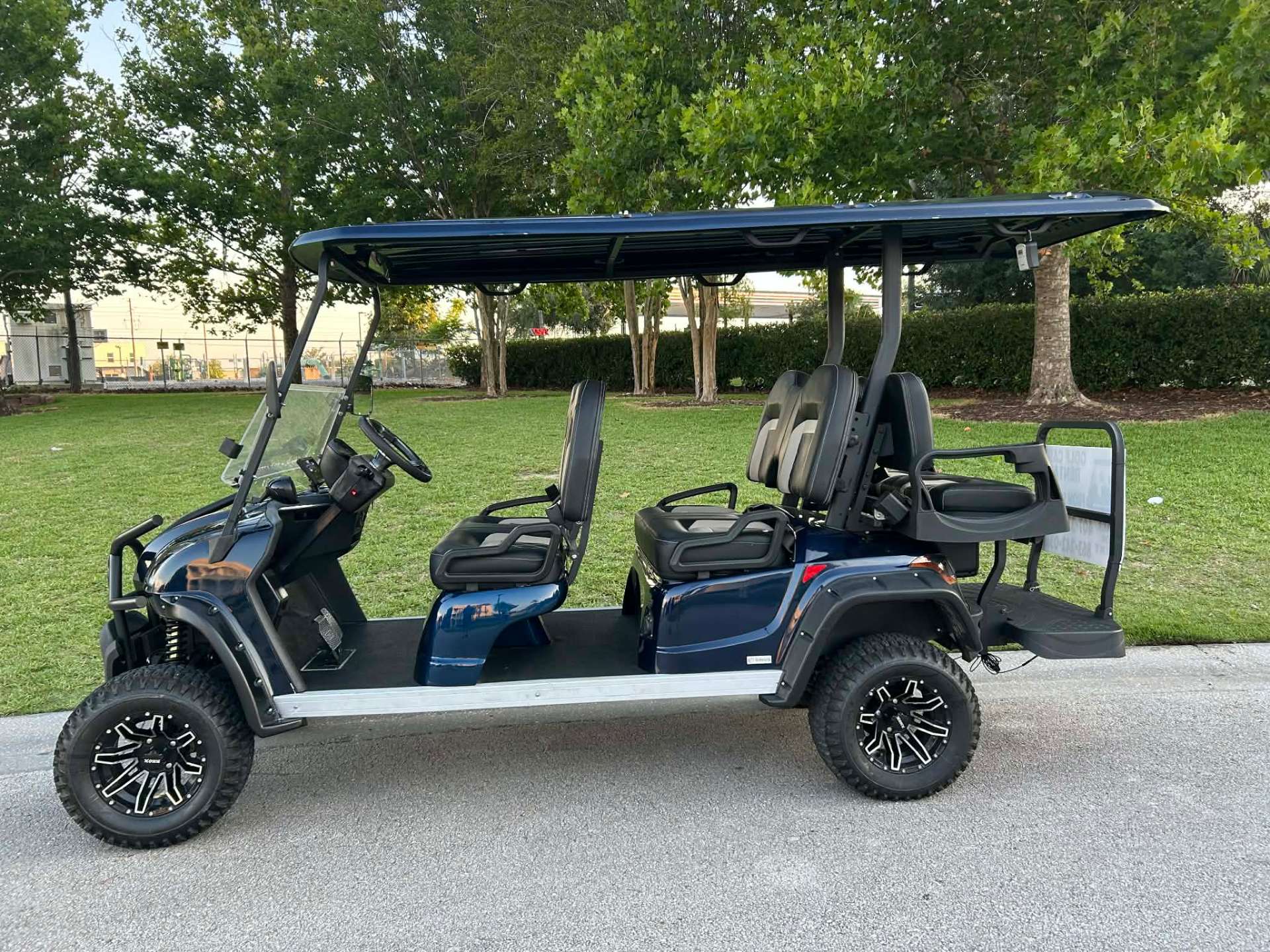 Navy blue 6-passenger luxury golf cart rental at an Orlando area park