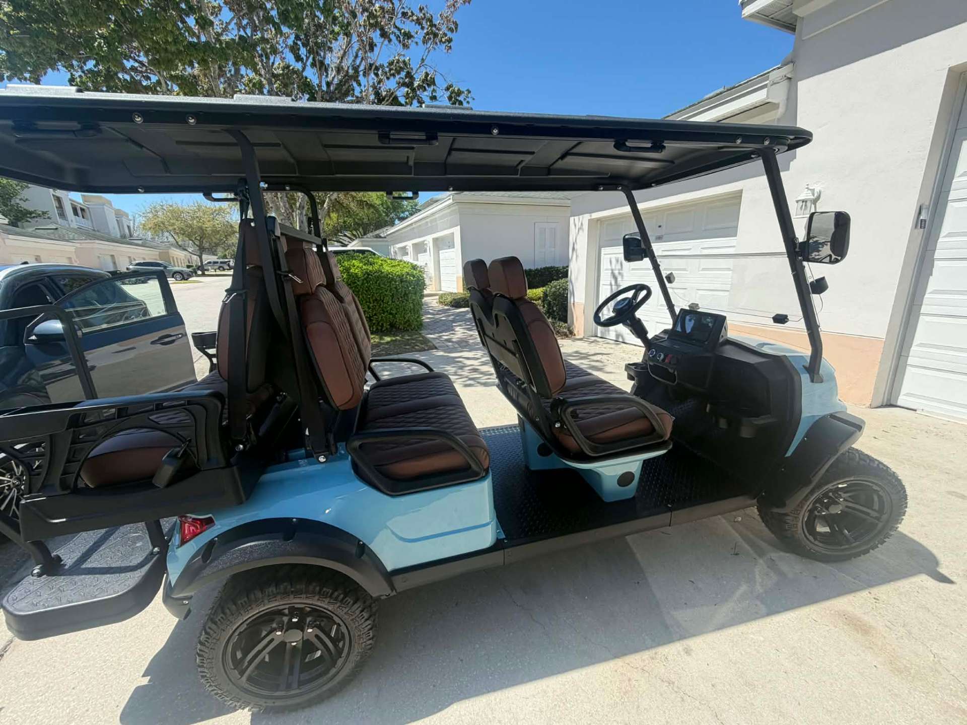 Interior view of teal 6-seater luxury golf cart with brown quilted leather seats