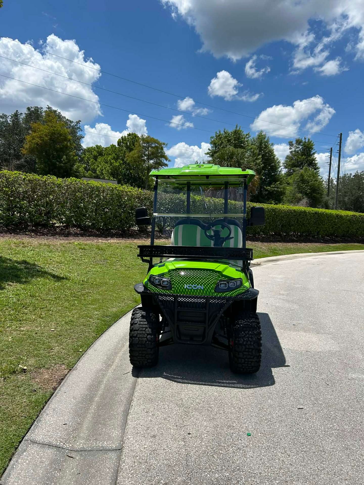 Front view of bright green ICON luxury golf cart on a Reunion Resort walking path