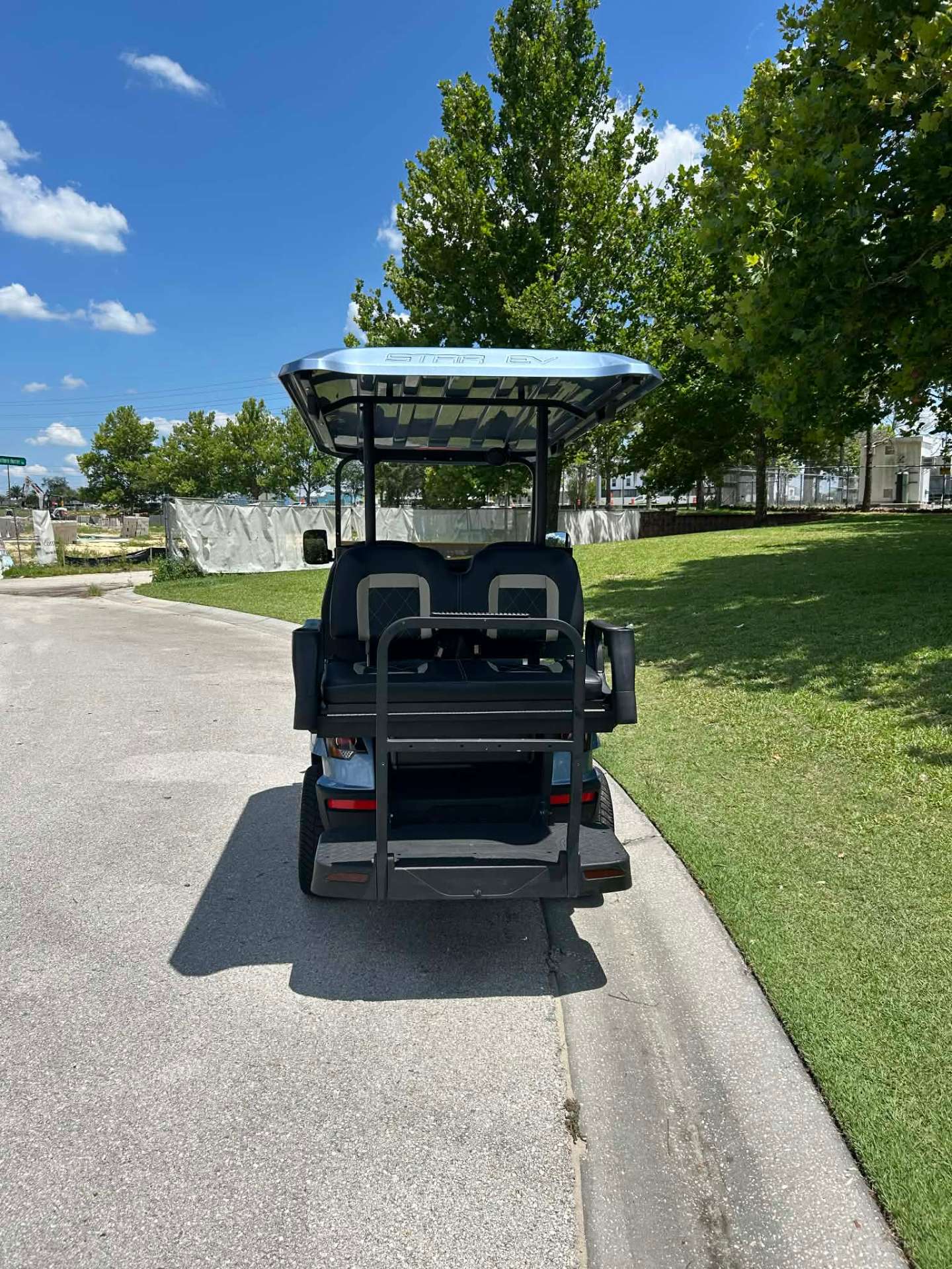 Rear view of light blue Star EV luxury golf cart with fold-down back seat